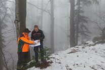 Zwei Männer stehen im Nebel in einem Wald