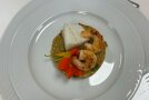 Weißer Speisenteller auf dem Fisch und Garnelen angerichtet sind