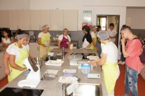 In einer Lehrküche arbeiten viele Frauen, andere schauen zu. Fotos 