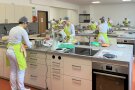 Blick in die Schulküche, wo an allen Arbeitsplätzen vorbereitet und gekocht wird