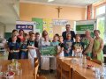 Kinder zeigen ihr Backwerk in der Schulküche. Gruppenbild mit allen Beteiligten, mit Bürgermeister und Schulleiterin.