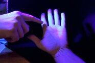 Hände werden von UV-Licht angestrahlt.