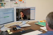 Schulleiter Josef Groß sitzt vor dem PC in seinem Büro und nimmt am digitalen Unterricht der Studierenden teil. 
