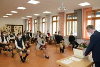 Studierende sitzen mit Abstand in Saal, Josef Groß spricht zu ihnen